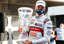 Nico Müller celebrates with his trophy whilst wearing a mask